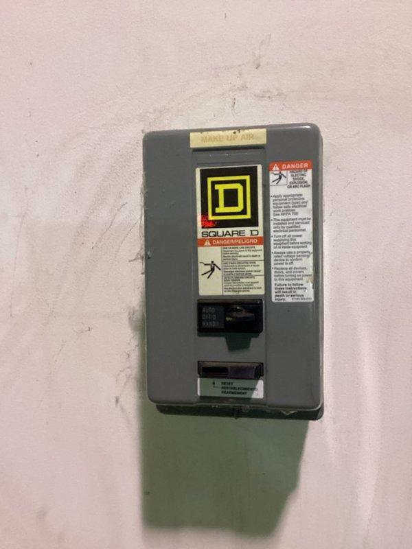 Completed site visit to inspect ground-level air make-up unit not heating properly for commercial client. Examined Square D electrical panel with specific "MAKE UP AIR" designation and inspected ICE control panel featuring blower controls, heat function, safety relay indicators, and temperature regulation system. Part ordered with expected arrival on 1/8; will coordinate with operations manager Les before proceeding with installation or additional service.