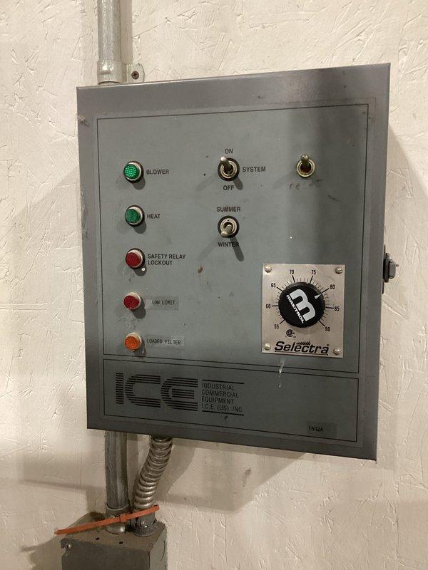 Completed site visit to inspect ground-level air make-up unit not heating properly for commercial client. Examined Square D electrical panel with specific "MAKE UP AIR" designation and inspected ICE control panel featuring blower controls, heat function, safety relay indicators, and temperature regulation system. Part ordered with expected arrival on 1/8; will coordinate with operations manager Les before proceeding with installation or additional service.