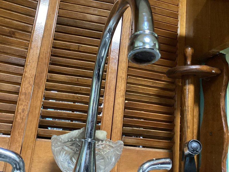 Responded to service call regarding low water pressure at kitchen faucet. Upon inspection, determined blockage in faucet aerator was restricting water flow. Removed aerator, cleaned calcium and sediment buildup, and reinstalled. Tested water flow which returned to normal pressure and function.