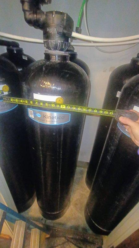 Responded to service call for a Kinetico water softener stuck in "dump" mode. Diagnosed faulty valve mechanism in the 16-year-old unit causing continuous regeneration cycle. Took measurements of the system components and inspected the cylindrical filtration tanks to determine appropriate replacement parts. Restored system to normal operation by repairing the malfunctioning valve assembly.