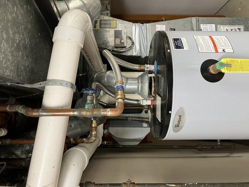 Installed a new 50-gallon Whirlpool draft vent water heater with expansion tank in utility area. Completed all necessary copper and PVC pipe connections, ensuring proper fittings and valve installations. System was tested and confirmed to be functioning correctly with no leaks observed.