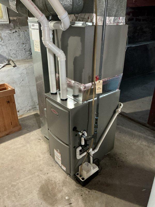 Completed warranty replacement of residential furnace in basement utility area. Installed new unit with proper ventilation system including PVC pipes and condensate drainage. Post-installation diagnostics confirmed system operating at 52.9° according to UEI measurement device.