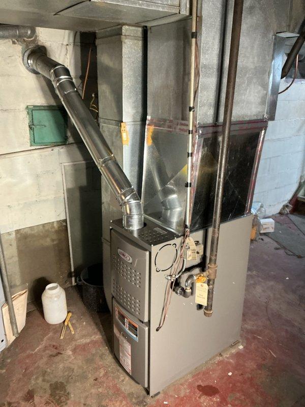 Successfully installed Lennox ML180UH045E36AK furnace with chimney liner and T4 thermostat, connecting to existing filter return system. System testing confirmed proper operation with supply air temperature reaching 90.3°F. Installation completed in basement utility area with all ductwork properly secured and connected.