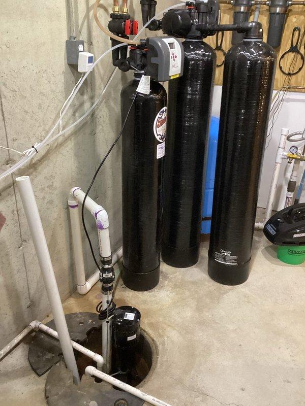 Responded to service call for sump pump drainage issue. Inspected outdoor utility area and basement water treatment system. Diagnosed and cleared clog in sump pump discharge line, restoring proper drainage function. Verified pump operation and confirmed pit water level properly receding after repair.
