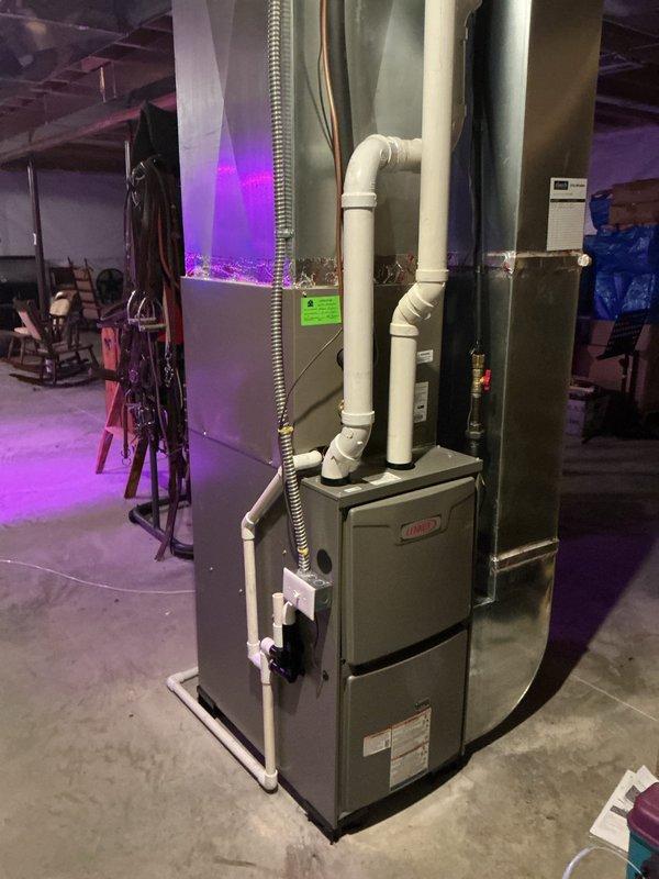 Completed installation of Lennox ML196UH070XE36BK furnace with L.P. kit in customer's basement. System includes proper PVC ventilation/drainage components and flexible metal ductwork connections. Verified unit functioning correctly with all connections secure.