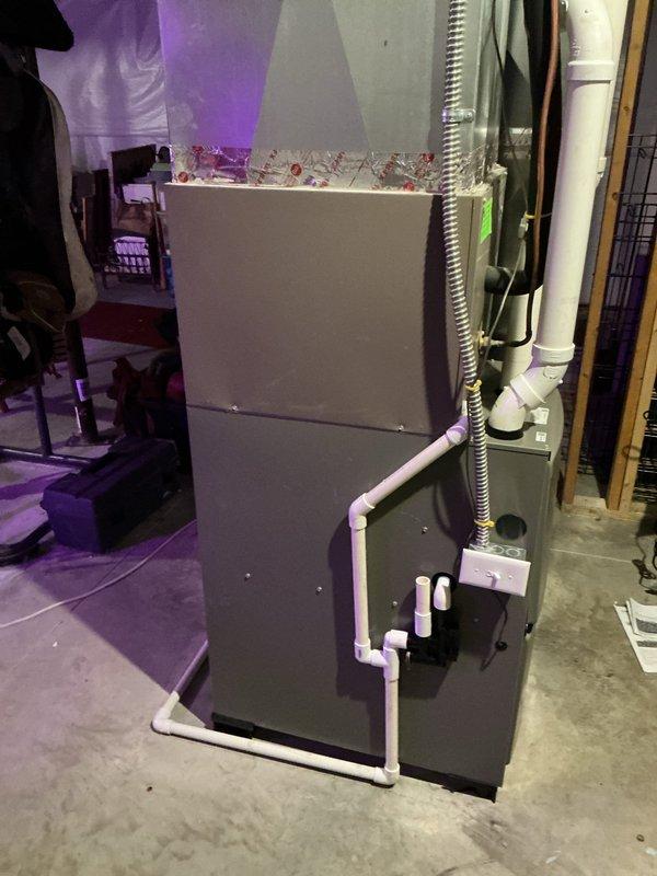 Completed installation of Lennox ML196UH070XE36BK furnace with L.P. kit in customer's basement. System includes proper PVC ventilation/drainage components and flexible metal ductwork connections. Verified unit functioning correctly with all connections secure.
