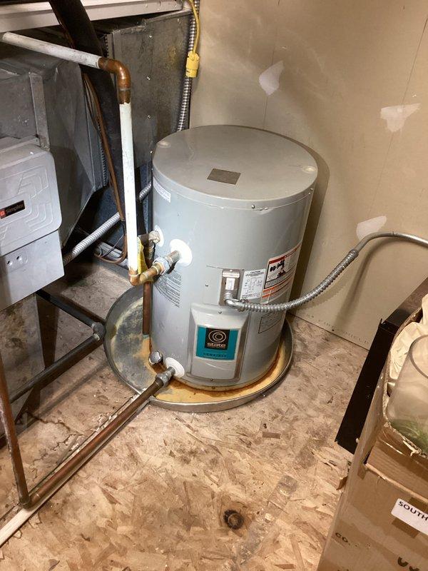 Responded to service call for water heater leaking at base connection to drain. Upon inspection, found minor leak at drain valve connection that was previously contained by customer with towels. Tightened connection and replaced deteriorated valve gasket. Verified proper operation and confirmed no further leakage from tank or connecting pipes. System is now functioning correctly with no signs of water loss.