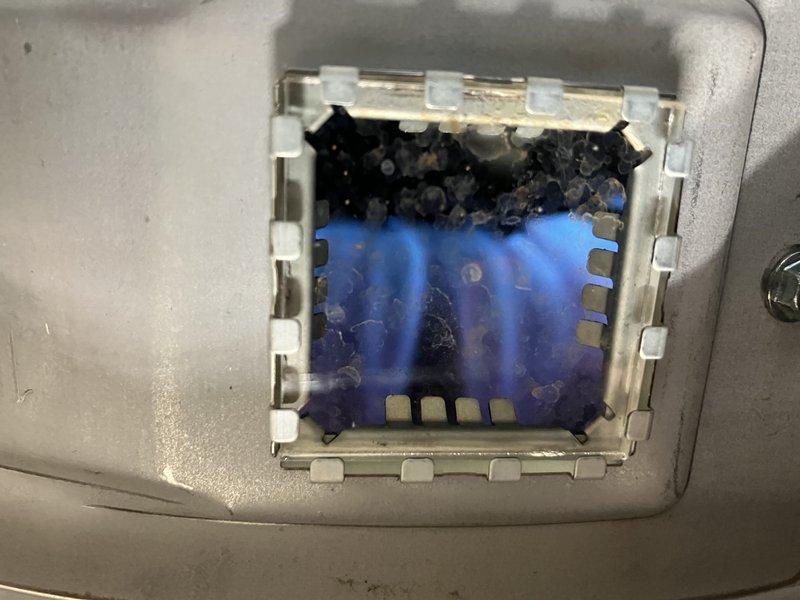 Responded to service call for 7-year-old tanked water heater experiencing intermittent operation issues. Inspection revealed proper flame pattern with strong blue combustion, indicating good gas supply. Cleaned debris accumulation from burner assembly and verified proper ignition sequence to resolve the intermittent lighting problem.