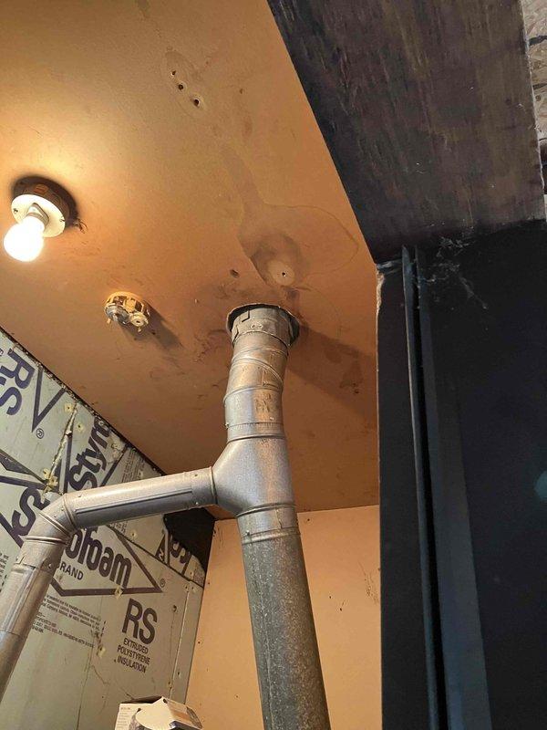 Conducted diagnostic assessment on non-operational furnace system after gas company identified rusted vent pipe as cause of failure. Inspection revealed significant water damage around ceiling penetration and corrosion on the exhaust components. Measurements were taken (73" x 51.5") for complete HVAC system replacement due to age-related deterioration and safety concerns with the existing unit.