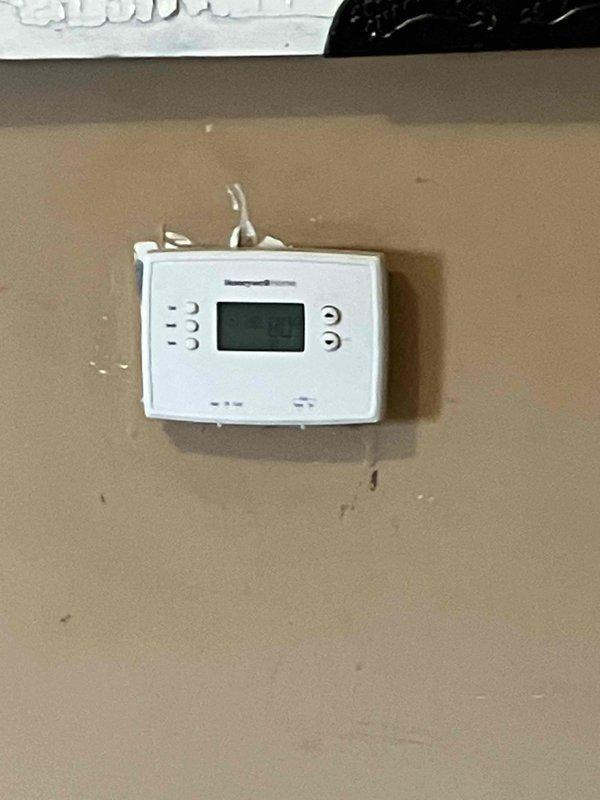 Conducted a comprehensive evaluation of the residence's aging HVAC system, including inspection of the weathered outdoor condenser unit showing visible corrosion and dirt accumulation on the coil sections. Assessment included examination of the existing Honeywell thermostat functionality and current system performance to determine optimal replacement options for the client's heating and cooling needs.