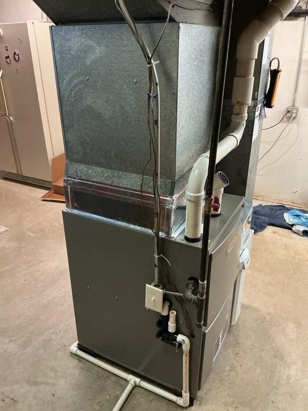 Successfully installed a Lennox ML196UH090XE48C furnace with 1610 media filter in basement utility area. Properly connected white PVC drain lines and exhaust/intake piping, secured electrical wiring with zip ties, and reconnected to existing thermostat. Installation completed with organized piping connections and proper ductwork integration.