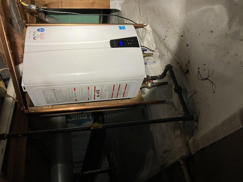 Performed scheduled A/C tune-up service with customer-provided 16x25x3 filter. Inspected tankless water heater installation in utility area, verifying proper connection of copper piping, brass fittings, and operational status of digital control panel. System functioning as designed with no issues identified.