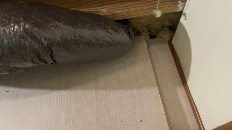 Completed ductwork renovation in unfinished basement utility area. Installed new insulated black duct through ceiling joists and added silver foil insulated ductwork with diamond pattern texture in adjacent area. Ensured proper sealing at wall junctions and verified all connections were secure for optimal HVAC system performance.