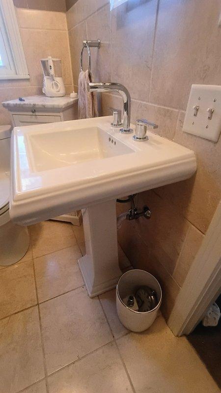 Responded to service request for bathroom faucet installation. Customer provided Kohler faucet which was successfully installed on white pedestal sink. Verified proper functionality of both hot and cold water handles and ensured no leaks at connection points.