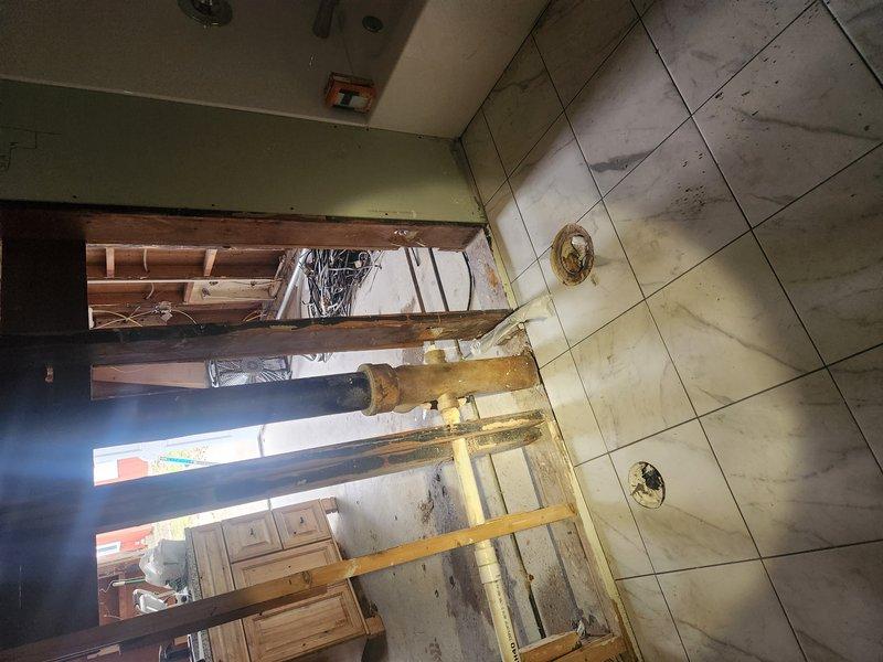 Conducted comprehensive inspection of utility closet plumbing system, identifying broken pipes and assessing water damage to surrounding walls. Evaluated existing copper supply lines, PVC drainage components, and brass fittings for functionality and code compliance. Documented exposed plumbing infrastructure in bathroom/utility area requiring renovation, including deteriorated floor tiles and compromised wooden framing around plumbing penetrations.