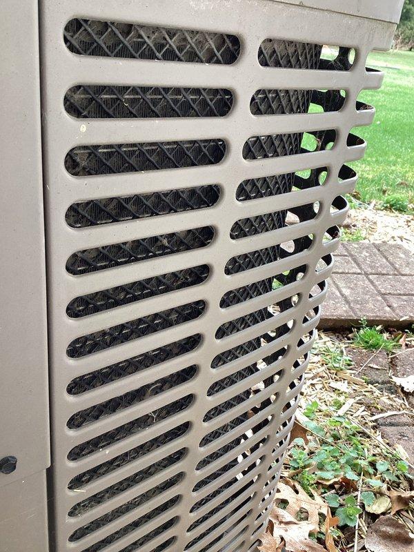 Performed scheduled maintenance on 14-year-old HVAC system under Gold Level service agreement. Inspected exterior condenser unit, confirming proper ventilation through horizontal slots and checking condition of housing which showed only minor weathering. Visual assessment of coils and surrounding area completed with photo documentation; system is functioning within normal parameters.