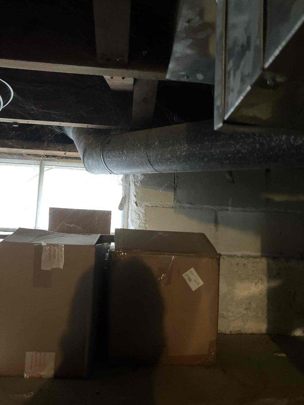 Conducted site assessment for potential HVAC replacement in basement utility area. Inspected existing ductwork system and evaluated current installation space with unfinished ceiling joists and concrete block walls. Noted potential moisture concerns on lower wall sections that may require remediation before new system installation. Photos taken to document current conditions for proper system sizing and installation planning.