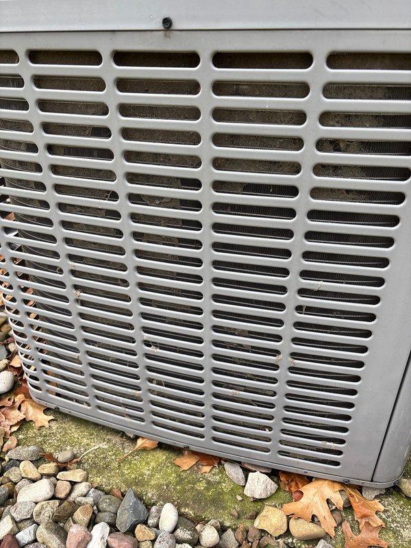 Performed routine A/C maintenance on outdoor condensing unit as part of scheduled service plan. Cleaned condensing unit exterior, removing accumulated dust, debris, and cobwebs from ventilation grille to improve airflow and system efficiency. Cleared surrounding area of fallen leaves to prevent potential airflow restriction and ensure proper unit operation.