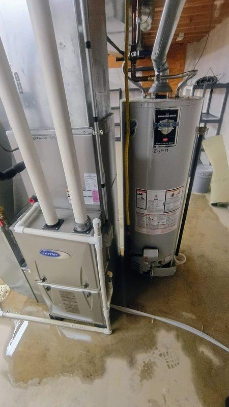 # Service Report: Tanked Water Heater Replacement

Responded to service call for customer reporting no hot water and visible water leakage from aging water heater estimated at 15-20 years old. Upon arrival, conducted thorough inspection of basement mechanical room and confirmed unit was non-operational with active leaking at base, evidenced by fresh water staining and pooling on concrete floor surrounding equipment.

Assessed existing tanked water heater installation including gas supply line connections, venting system with metal ductwork, and associated plumbing connections. Documented equipment condition through photographic evidence showing compromised tank integrity and water damage to surrounding floor area. Evaluated manufacturer specifications and determined unit had exceeded expected service life and was beyond economical repair.

Presented customer with diagnostic findings and recommended full water heater replacement due to tank failure and age-related deterioration. Upon ap