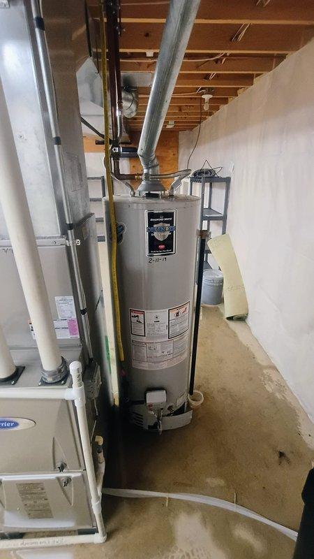 # Service Report: Tanked Water Heater Replacement

Responded to service call for customer reporting no hot water and visible water leakage from aging water heater estimated at 15-20 years old. Upon arrival, conducted thorough inspection of basement mechanical room and confirmed unit was non-operational with active leaking at base, evidenced by fresh water staining and pooling on concrete floor surrounding equipment.

Assessed existing tanked water heater installation including gas supply line connections, venting system with metal ductwork, and associated plumbing connections. Documented equipment condition through photographic evidence showing compromised tank integrity and water damage to surrounding floor area. Evaluated manufacturer specifications and determined unit had exceeded expected service life and was beyond economical repair.

Presented customer with diagnostic findings and recommended full water heater replacement due to tank failure and age-related deterioration. Upon ap