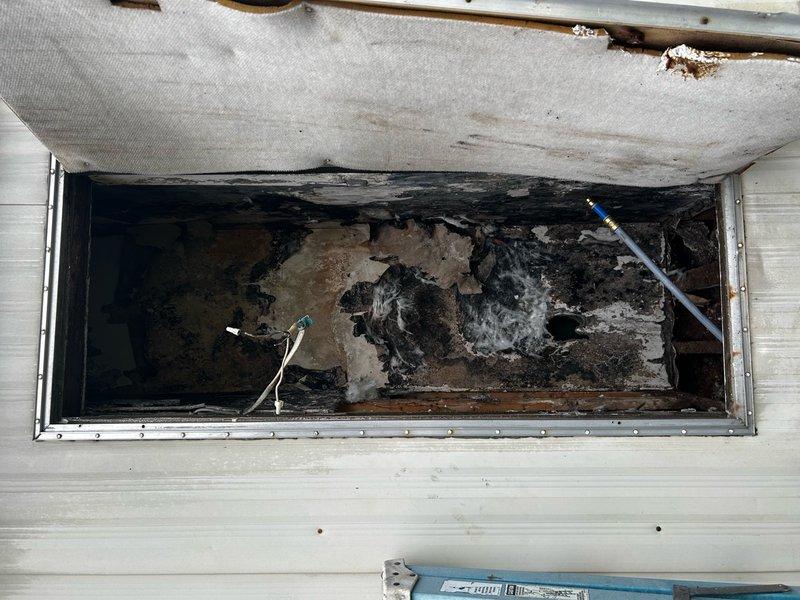 # Plumbing Inspection - Fire-Damaged Trailer

Completed comprehensive plumbing inspection of fire-damaged trailer to assess extent of damage and determine repair requirements. Inspection focused on evaluating water supply piping, water heater connections, and overall plumbing infrastructure condition following fire incident.

## Inspection Findings

Accessed crawl space and utility areas to examine plumbing system components. Documented extensive fire and heat damage throughout accessible areas, with significant deterioration of structural elements and plumbing infrastructure. Water supply lines showed evidence of exposure to extreme temperatures, with visible damage to pipe insulation and surrounding materials.

Examined existing piping beneath structure, which displayed severe corrosion, rust accumulation, and compromised integrity due to fire exposure and subsequent environmental conditions. Metal components exhibited advanced oxidation with heavy surface deterioration. Water heater