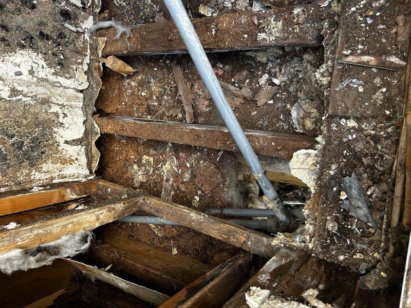 # Plumbing Inspection - Fire-Damaged Trailer

Completed comprehensive plumbing inspection of fire-damaged trailer to assess extent of damage and determine repair requirements. Inspection focused on evaluating water supply piping, water heater connections, and overall plumbing infrastructure condition following fire incident.

## Inspection Findings

Accessed crawl space and utility areas to examine plumbing system components. Documented extensive fire and heat damage throughout accessible areas, with significant deterioration of structural elements and plumbing infrastructure. Water supply lines showed evidence of exposure to extreme temperatures, with visible damage to pipe insulation and surrounding materials.

Examined existing piping beneath structure, which displayed severe corrosion, rust accumulation, and compromised integrity due to fire exposure and subsequent environmental conditions. Metal components exhibited advanced oxidation with heavy surface deterioration. Water heater