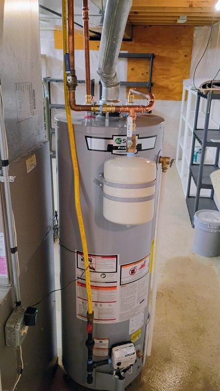 Completed installation of new tanked water heater in residential basement utility area per previously approved quote. Unit was properly positioned and secured, with all necessary connections completed including cold water inlet, hot water outlet, temperature and pressure relief valve discharge piping, and gas supply line. Flexible gas connector was installed and tested for leaks, copper supply lines were connected with appropriate shut-off valves, and proper venting was established to existing ductwork. All plumbing connections were tightened to specification and the installation meets current code requirements for residential water heater systems.
