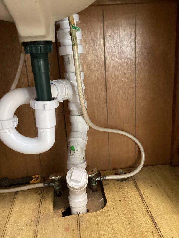 Replaced and reconfigured the drain line assembly for the downstairs bathroom sink. Installed new white PVC P-trap system with proper connections from the sink drain to the main waste line, ensuring correct slope and secure fittings throughout. Verified all connections are leak-free and drainage flows properly.