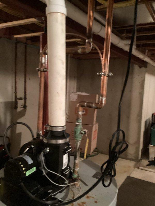 Conducted on-site evaluation of residential gas water heater located in basement utility area. Inspected tank-style water heater with atmospheric venting, confirmed gas fuel source via yellow flexible gas line connection, and assessed copper supply piping and electrical control components. Documented equipment condition and specifications to provide replacement estimate.