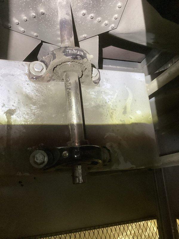 Responded to service call for 22-year-old heating system experiencing loud noise described as similar to a baseball bat hitting metal. Upon inspection, diagnosed worn blower motor bearings on air handler unit, evidenced by excessive noise during operation and visible wear on Timken bearing assembly. Inspected pulley system, motor mounting brackets, and ductwork connections for additional damage or misalignment. Documented condition of equipment with photographs showing bearing assembly, mounting hardware, and surrounding components including filter and ductwork with moisture accumulation and age-related staining. Advised homeowner of findings and recommended replacement of blower motor bearings to restore quiet operation and prevent potential motor failure.
