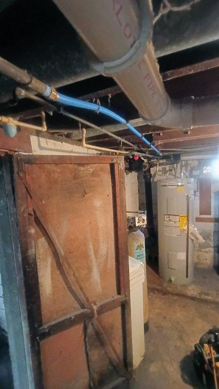 Completed inspection of residential plumbing system in basement area to assess refrigerator water line replacement requirements. Customer requested replacement of existing copper supply line to accommodate new refrigerator installation. Inspected current water line configuration, basement utility area conditions, and existing plumbing infrastructure including exposed piping, PEX water lines, and connection points. Documented site conditions with photographs showing basement mechanical room layout, water heater location, and accessible plumbing routes for potential water line installation.