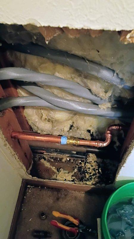 Responded to water leak originating from outdoor spigot penetrating into interior space. Upon arrival, water supply was still active. Accessed affected area through ceiling opening to expose plumbing infrastructure. Located failed outdoor hose bib connection where copper supply line penetrated building envelope. Replaced defective spigot assembly with frost-proof sillcock, installed new copper fittings, and soldered connections to ensure watertight seal. Tested system under full pressure to verify repair integrity and confirmed no active leakage at interior or exterior connection points.