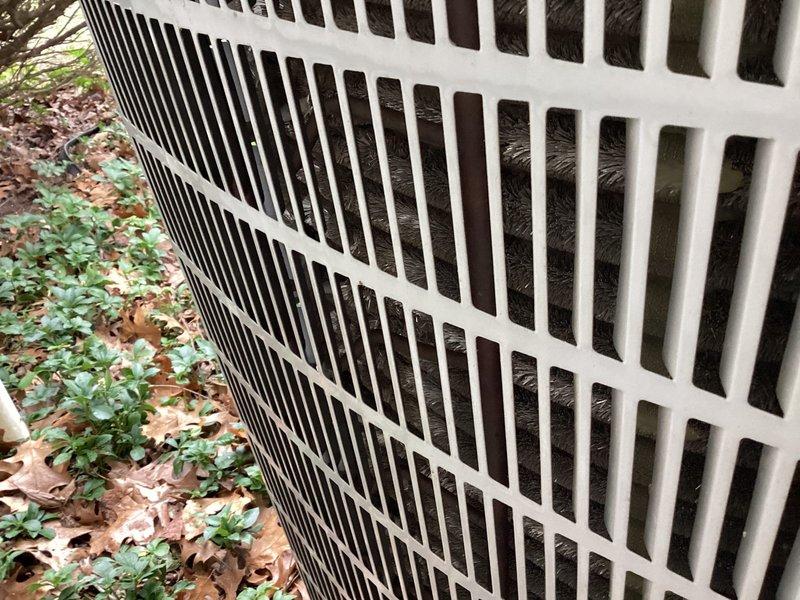 Completed scheduled A/C maintenance on outdoor condensing unit, including installation of 410 filter that was missed during previous appointment per membership agreement. Unit inspected and photographed showing protective grille in good condition with visible debris accumulation on coils and surrounding area requiring attention during service.