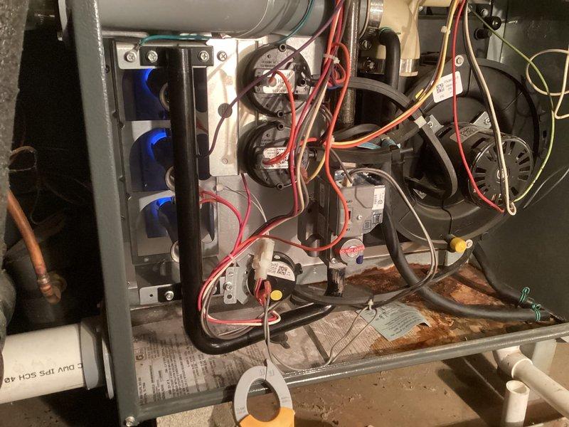 Responded to no heat call on furnace unit under 10 years old. Upon inspection, found unit with accumulated corrosion debris at base and accessed internal components to diagnose heating failure. Inspected burner assembly with flame sensors, verified electrical connections at terminal block, and examined wiring harness for proper continuity. Unit restored to proper operation with heat confirmed at registers.