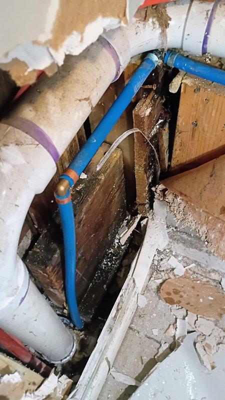 Responded to water leak in laundry room with water supply already shut off by customer. Upon inspection, identified failed sensor module on water supply line causing active leak. Accessed plumbing through floor cavity to locate source of leak on blue PEX water line with brass compression fitting connection. Removed defective electronic sensor component from water supply system. Repaired compromised section of water line and replaced faulty connection point. Verified all connections were secure and leak-free before restoring water supply. Tested system under full pressure to confirm repair integrity. No standing water present at time of service or upon completion.