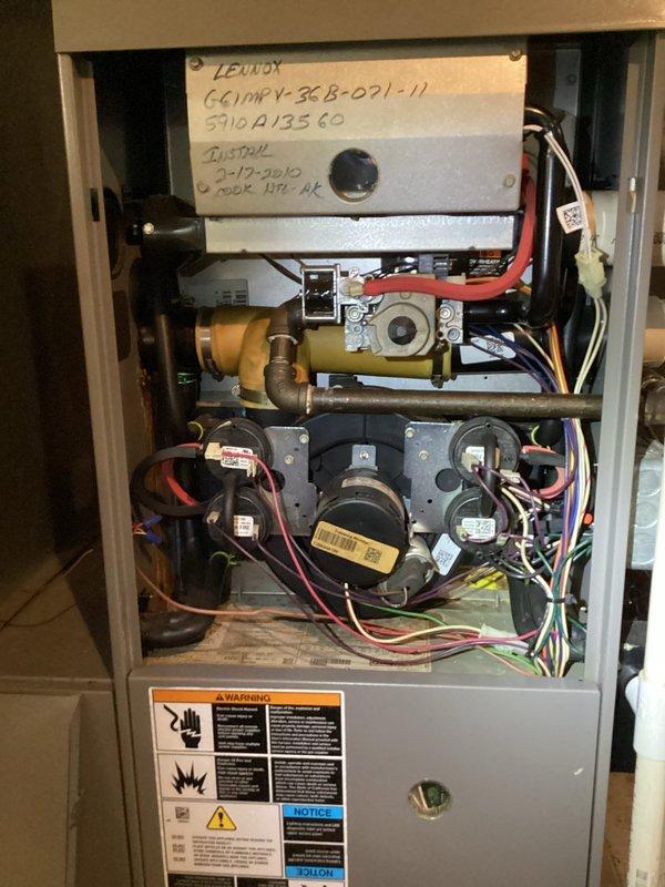 Responded to no heat call on 16-year-old Lennox G61MPV-36B-091-11 furnace system blowing room temperature air with thermostat set to 76°F and home temperature at 70°F. Upon arrival, confirmed airflow present but no heat output. Removed front access panel and performed visual inspection of internal components including blower motor, ignition system, and gas valve assembly.

Discovered significant frost and ice buildup in ductwork system, indicating restricted airflow condition. Ice accumulation observed throughout interior duct surfaces with crystalline formation along circumference. This restriction prevented proper heat exchange and system operation. Identified cause as dirty/restricted air filter creating negative pressure and reduced airflow across heat exchanger, resulting in temperature drop and subsequent condensation freezing in ductwork.

Addressed immediate airflow restriction by removing ice buildup from affected ductwork sections. Installed new 16x25x5 media filter to restor