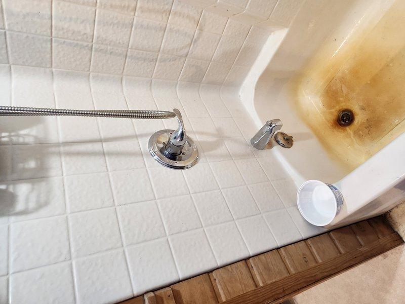 Installed new Delta shower and tub valve assembly with trim kit in existing bathtub enclosure. Accessed plumbing infrastructure through wall opening to connect supply lines to valve body using copper piping with brass compression fittings and PEX connections for hot and cold water supply. Mounted chrome shower fixture and faucet assembly on tiled wall surface and completed installation with proper trim kit components.