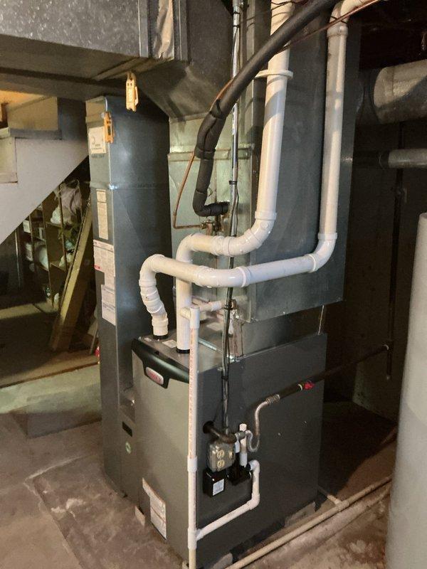 Completed installation of Lennox EL297UH070 high-efficiency furnace in residential basement utility area, including proper PVC venting configuration and connection to existing return air filter system. Installed T6 non-programmable thermostat and verified all electrical connections, gas supply lines, and condensate drainage are functioning properly. System tested and operational with all safety controls confirmed.