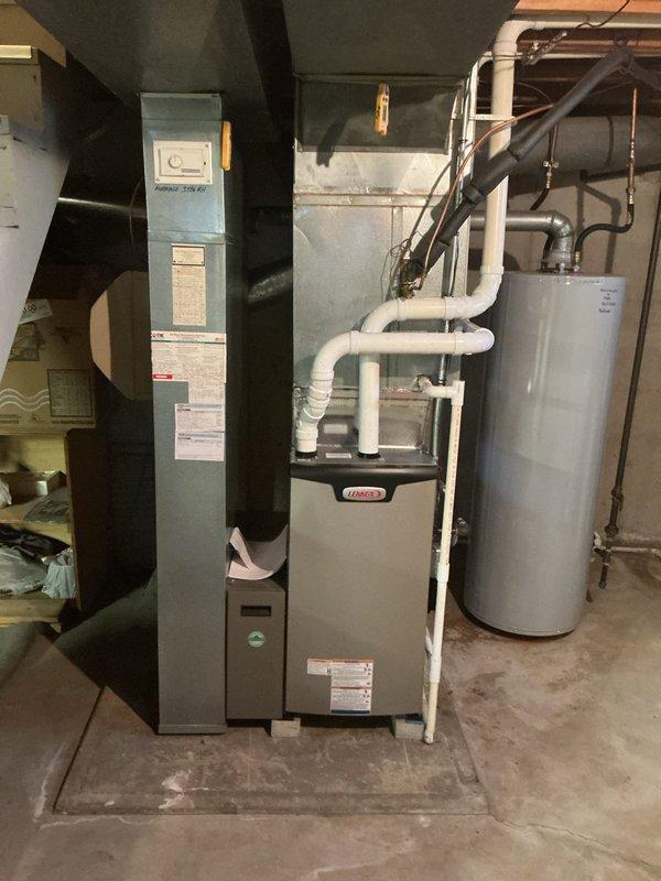 Completed installation of Lennox EL297UH070 high-efficiency furnace in residential basement utility area, including proper PVC venting configuration and connection to existing return air filter system. Installed T6 non-programmable thermostat and verified all electrical connections, gas supply lines, and condensate drainage are functioning properly. System tested and operational with all safety controls confirmed.