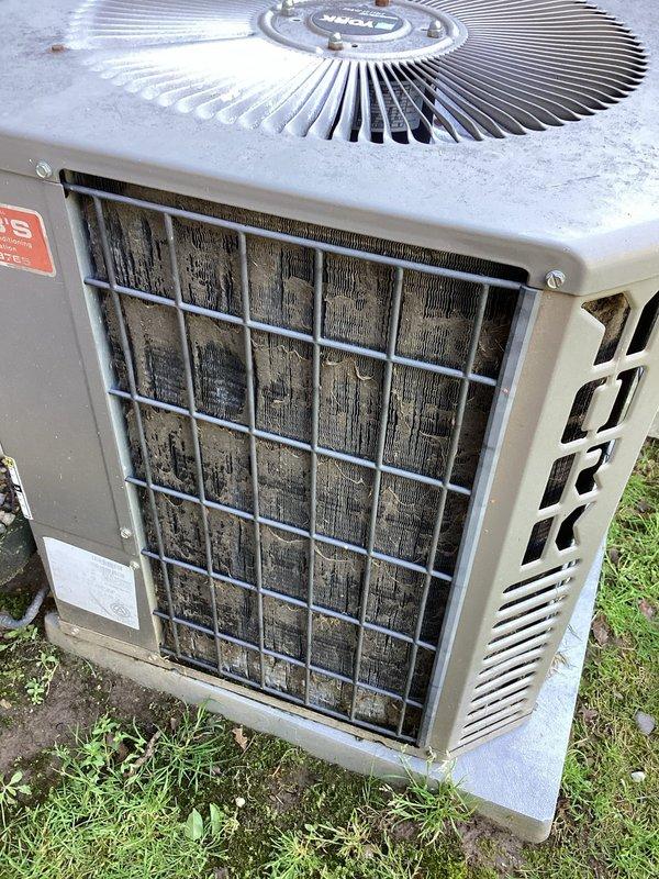 Completed planned air conditioning maintenance on two outdoor condensing units. Performed comprehensive system inspection including visual assessment of both units, with one located in a confined side yard area and another positioned on a concrete pad. The unit on the concrete pad exhibited heavy accumulation of dirt, dust, and debris caked throughout the condenser coils and fins, significantly restricting airflow. Cleaned condenser coils to restore proper heat transfer efficiency and airflow capacity. Replaced 16x20x1 air filter as part of routine maintenance protocol. Inspected electrical connections, refrigerant lines, and mechanical components on both units for proper operation and signs of wear. Documented equipment condition through photographic records showing before-condition of heavily soiled coils and overall unit placement. All systems operational upon completion of maintenance service.