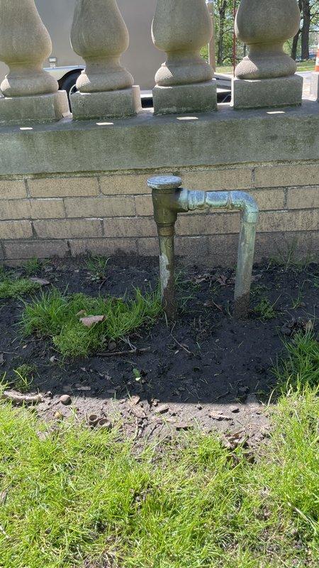Responded to water leak investigation at commercial facility. Inspected exterior drainage system at building foundation where downspout showed signs of corrosion and water accumulation at base, with soil erosion evident around discharge point. Evaluated interior utility sink area and associated plumbing infrastructure, documenting condition of PVC supply lines and shut-off valves for maintenance coordination as requested.