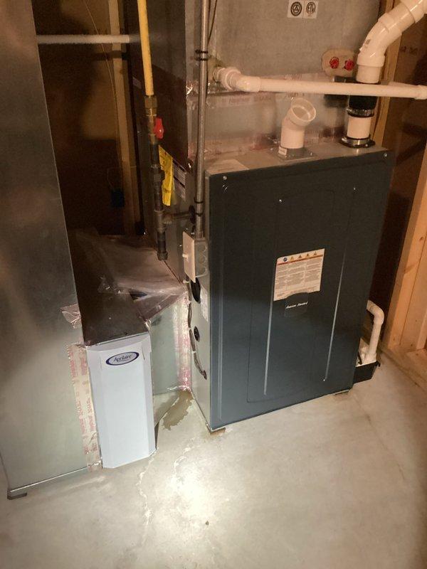 Responded to service call for air conditioning tune-up with reported water pooling issue at furnace. Upon arrival, performed comprehensive system inspection of 4-year-old HVAC unit. Examined furnace cabinet, condensate drainage system, and surrounding mechanical components for source of water accumulation. Inspected PVC condensate drain lines, fittings, and connections for proper pitch and flow. Checked condensate pump operation and discharge piping. Evaluated evaporator coil drain pan for cracks, overflow, or blockage. Assessed humidifier connections and water supply lines for potential leaks. Verified proper installation of all plumbing components and ductwork connections. Examined air handler cabinet for signs of moisture intrusion or condensation issues. Tested system operation to identify any active leaking during runtime. Documented existing conditions with photographs of mechanical room setup, including furnace unit, ductwork, PVC piping, humidifier installation, and surrounding