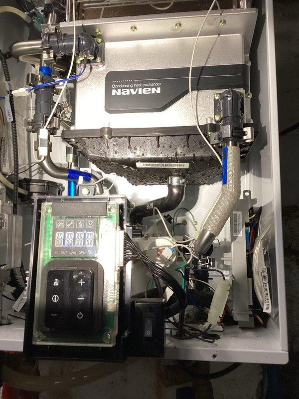 Responded to service call for tankless water heater with no hot water condition. Upon arrival, inspected Navien condensing tankless unit approximately 10 years old. Performed diagnostic evaluation of internal components including heat exchanger, gas valve assembly, and control board. Examined all water connections, gas lines, and electrical wiring for proper operation. Verified condensate drainage system and checked for any blockages or restrictions. Inspected circulation pump, flow sensor, and ignition system components. Documented equipment condition with photographs showing heat exchanger assembly, internal mechanical components, and control panel display. Unit assessed and findings provided to customer for next steps.