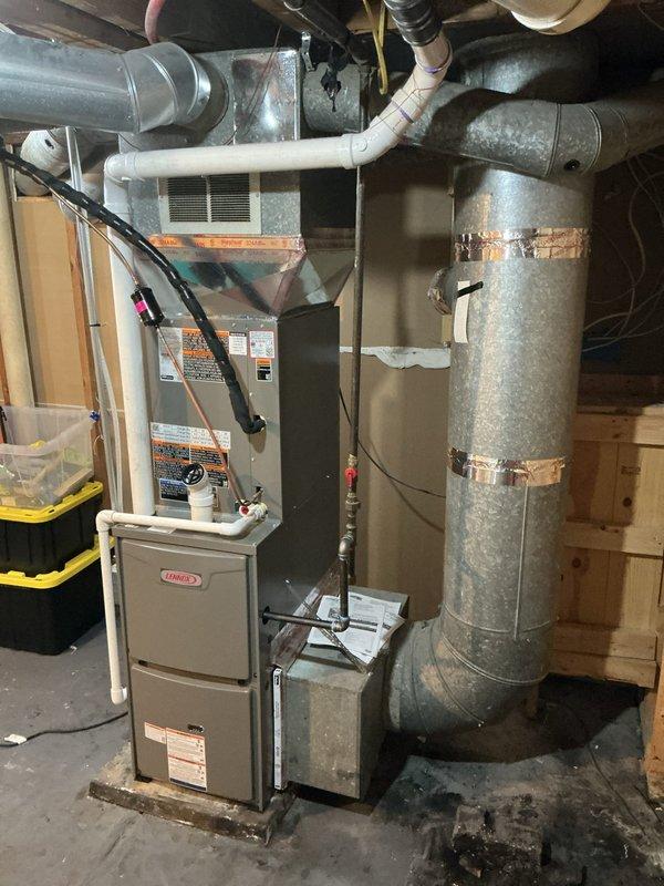 Completed full HVAC system installation featuring a Lennox ML196 high-efficiency gas furnace and ML13 air conditioning unit in basement utility area. Reused existing thermostat, filter rack, and condensate pump while re-routing the pump's discharge hose to the washing machine standpipe for proper drainage. Installed new 1-inch air filters and reconnected ductwork boot serving the nearby bathroom that had become detached. All ductwork connections were secured, electrical wiring was properly terminated, and system was tested for proper operation. Installation met manufacturer specifications and local code requirements.