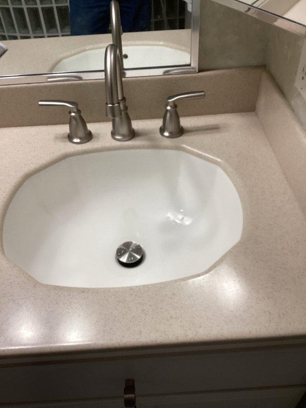 Successfully replaced two bathroom vanity faucets with customer-supplied Moen three-piece faucet assemblies, featuring brushed nickel finish with center-mounted high-arc spouts and dual side handles. Removed existing fixtures, installed new faucets with proper water supply connections, tested for leaks, and verified proper hot and cold water operation and drainage on both bathroom sinks.