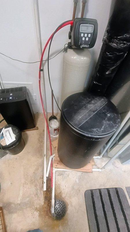 Responded to service call for Hero brand water softener system that had salt added by maintenance personnel approximately one year prior but remained undissolved in brine tank. Customer reported toilets running, indicating potential water flow issues. Performed comprehensive diagnostic inspection of water softener system including control head functionality, brine tank salt levels, and regeneration cycle operation. Evaluated plumbing connections, bypass valve positioning, and water distribution throughout residence. Documented existing dual water heater installation and complete water treatment system configuration with photographic evidence for service records.