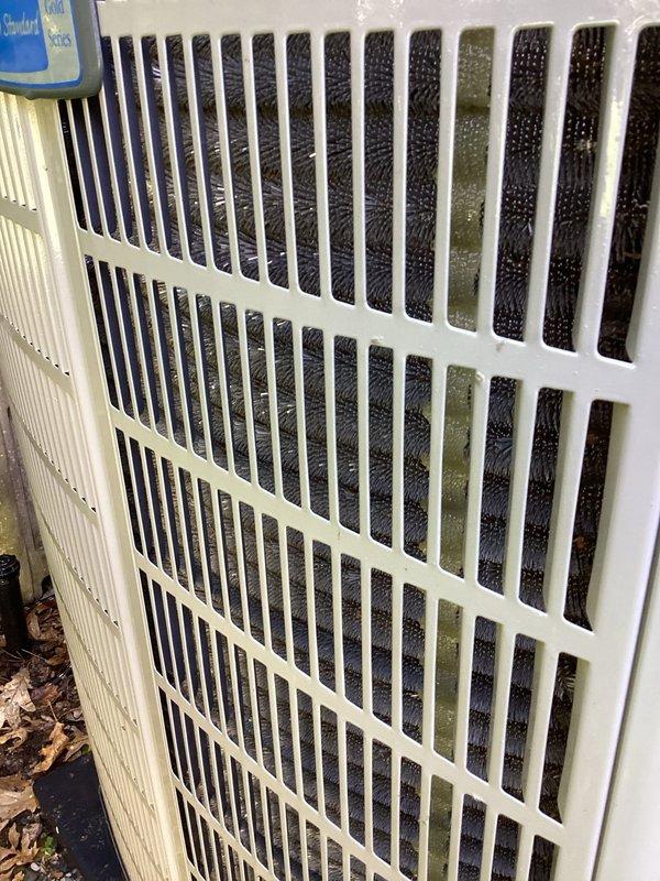Completed planned air conditioning maintenance per membership agreement. Inspected outdoor condensing unit and identified significant biological growth on condenser coils, particularly in upper sections, which can restrict airflow and reduce system efficiency. Documented condition of indoor air return grille showing accumulated dust and debris on filter media requiring attention. Unit operational at time of inspection.