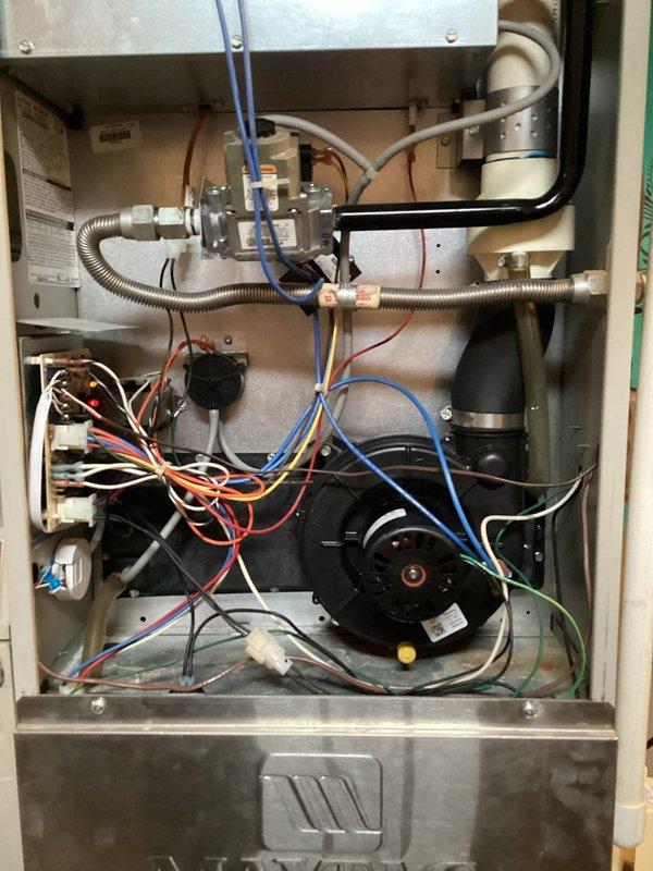 Completed planned HVAC maintenance and investigated heating system failure following recent A/C tune-up. Accessed interior compartment and inspected all mechanical and electrical components including gas valve assembly, blower motor, heat exchanger, and wiring connections. Noted rust and corrosion on base pan indicating previous moisture exposure. Verified all electrical connections, capacitor, and safety switches for proper operation to restore heating functionality.