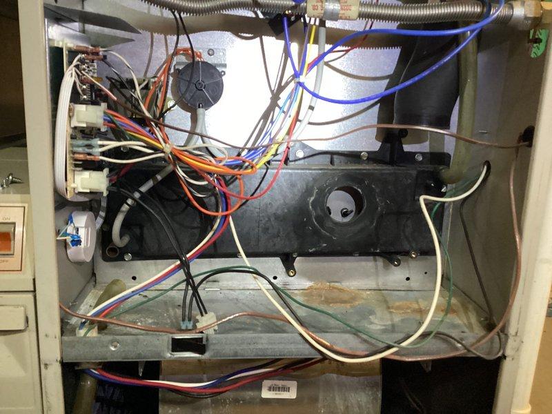 Completed planned HVAC maintenance and investigated heating system failure following recent A/C tune-up. Accessed interior compartment and inspected all mechanical and electrical components including gas valve assembly, blower motor, heat exchanger, and wiring connections. Noted rust and corrosion on base pan indicating previous moisture exposure. Verified all electrical connections, capacitor, and safety switches for proper operation to restore heating functionality.