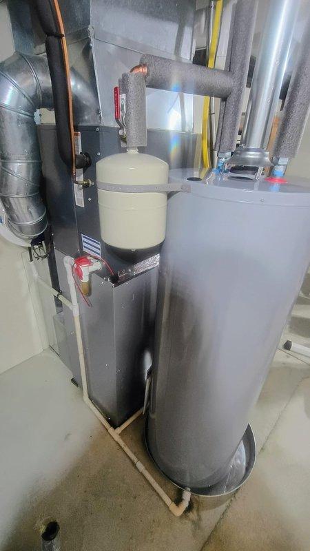 Installed AO Smith natural draft 40-gallon water heater in basement mechanical room with drain pan and expansion tank. Replaced quarter turn valve above unit and gate valve on water supply line to ensure proper shutoff capability and system protection.